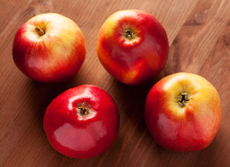 Four apples on a brown wooden table