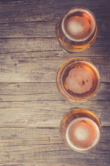 Overhead shot of beer glasses on an old wooden table