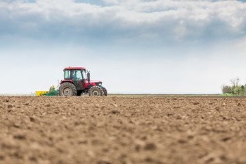 Obraz premium Farmer seeding, sowing crops at field