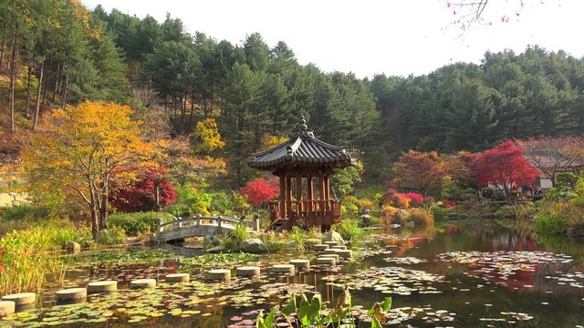 Pond with a small bridge and gazebo in The Garden of Morning Calm. Gapyeong