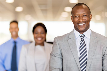 african businessman standing in front of colleagues
