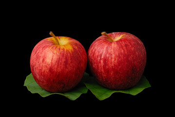 red apples with green leafs on black