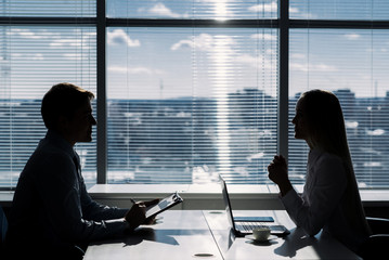 Fototapeta premium Outlines of two businessmen working late in office