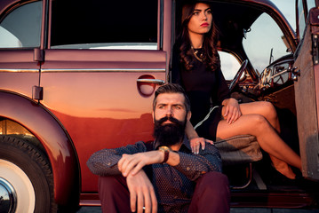 brutal bearded man with a mustache in a shirt, pants with suspenders with a girl with dark hair and...