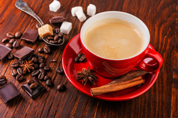  black coffee with dark chocolate, beans and sugar cubes on wooden background