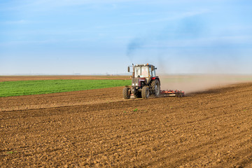 Tractor cultivating field at spring
