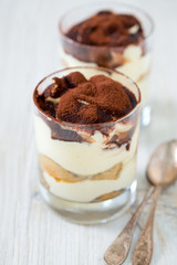 tiramisu in glass on wooden surface