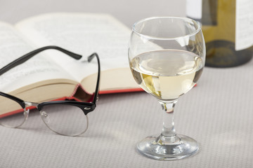 Glass of wine on a table with a open book