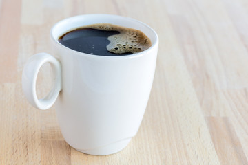 Cup of coffee on the wooden table, close-up