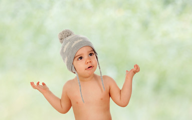 Adorable baby with wool cap asking somenthing
