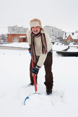 man cleans snow from roofs