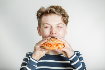 Boy Eating Burger Bun Topped with Shredded Carrots