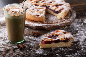 Delicious cake with cherries, icing sugar and a cup of coffee
