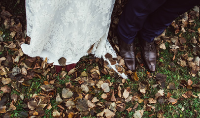 Shoes of bride and groom in fallen leaves