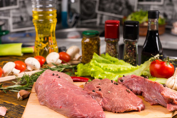 Three pieces of raw meat on table