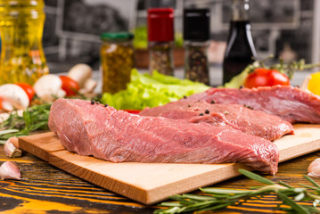 Cutting board with raw meat on top