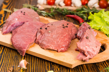 Cuts of meat with garlic clove on table