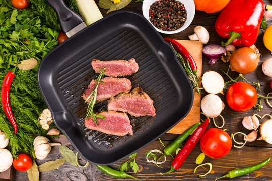Rare Beef Slices in Pan Surrounded by Ingredients