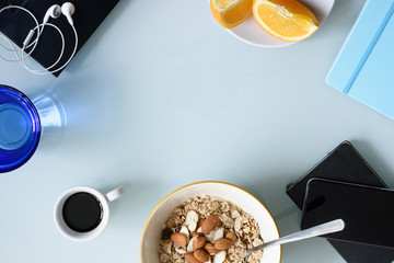 Morning coffee, breakfast, laptop and office supplies on office desk. Top view, copy space.