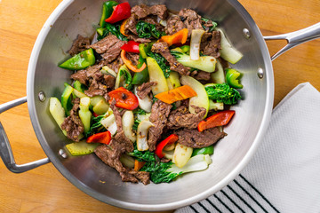 Beef stir fry top view. Healthy vegetable & beef stir-fry. Made with flank steak, peppers, onions and bok choy stir fried in an asian wok.
