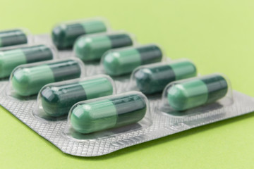 pills capsules medicine on green background