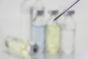 Needle of syringe with ampules on white background