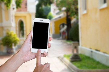 Hands woman are holding touch screen smart phone,tablet on blurred road and building with nature background.