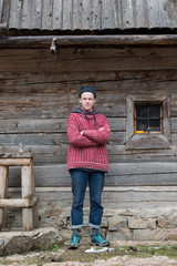 young hipster in front of wooden house