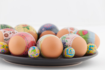 Easter eggs and chocolates on black plate closeup