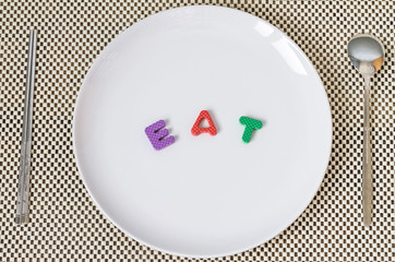 Empty plate with spoon and fork on wooden background