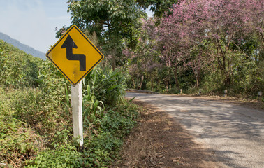 curvy road sign to the mountain in rural area