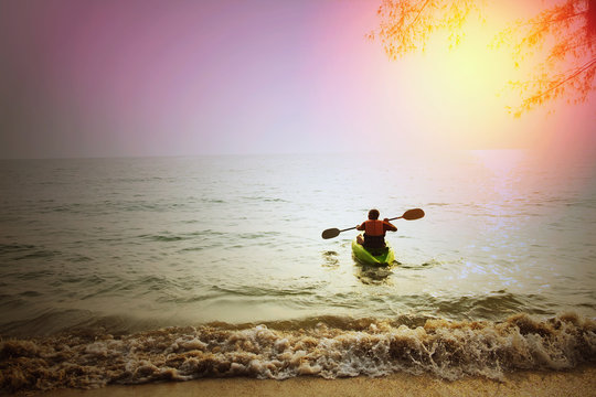 Skinhead Caucasian man on kayak on beach in summer / Skinhead Caucasian man on kayak on ocean near beach start new adventure in summer