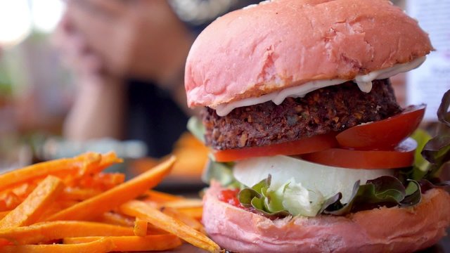Vegetarian Burger with Grilled Falafel , Vegetables, Greens and Carrot French Fries. Closeup. 
