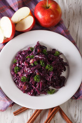 braised red cabbage with apples close up on a plate. Vertical
