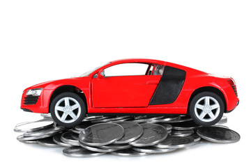 beautiful toy machine is on a pile of silver coins isolated on white background