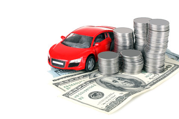 beautiful toy car is near on the banknotes and pile of silver coins stacked in columns , isolated on white background