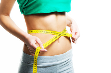 Woman measuring her waist with a measuring tape