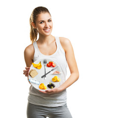 Beautiful young woman holding a plate with food, diet and time concept 
