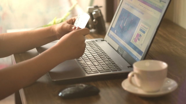 A man paying for online shopping using laptop and credit card. This image is illustrated the online payment concept via internet. Slightly warm tone filter.
