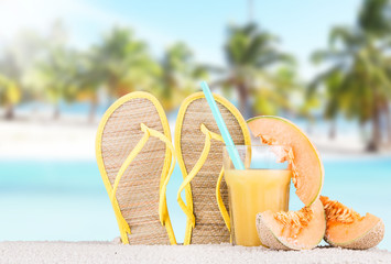 Summer concept of sandy beach, flip flops and starfish.