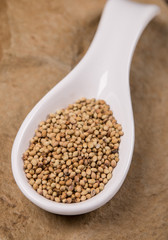 Mustard seeds in white spoon on stone