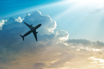 Fototapeta premium Samolot na niebie i chmura o wschodzie słońca