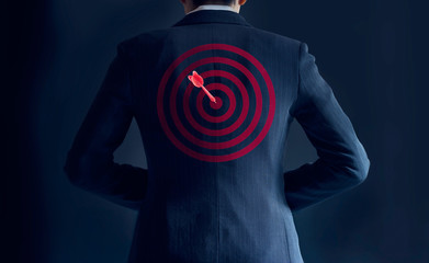 businessman get success with red arrow on target at the back of him