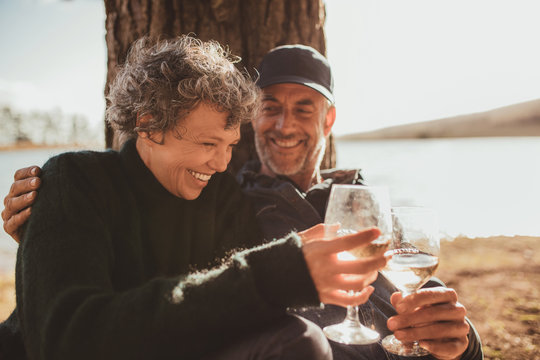 Relaxed mature couple having a glass of wine at campsite
