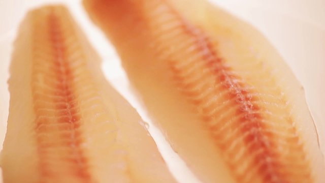 Raw fish fillet on a transparent plate