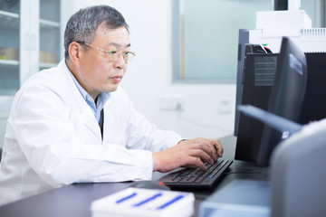 Fototapeta na wymiar Asian old man analysises experimental data in lab