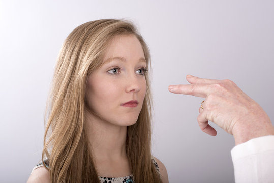 A two fingure gesture towards a young woman's eyes