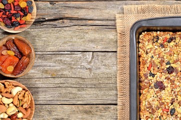 Ingredients for homemade granola bars - dried fruits, nuts, seeds and honey on wooden table.Copyspace background. Top view.