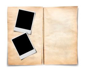Two photo frames on old open book on white background