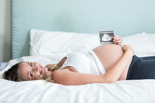 Pregnant woman showing an ultrasound picture